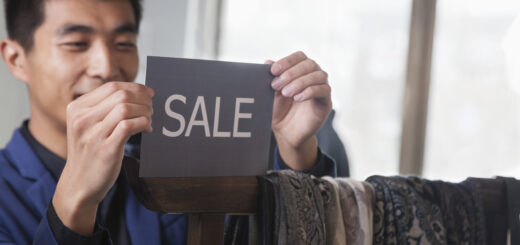 9187400_store-clerk-putting-up-for-sale-sign-at-fashion-store