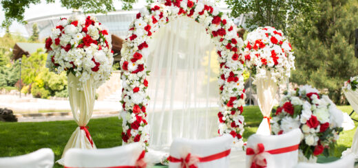 wedding-ceremony-outdoors-wedding-arch-decorated-with-red-flowers-scaled