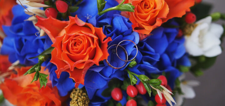 wedding-rings-on-red-roses-bouquet-scaled